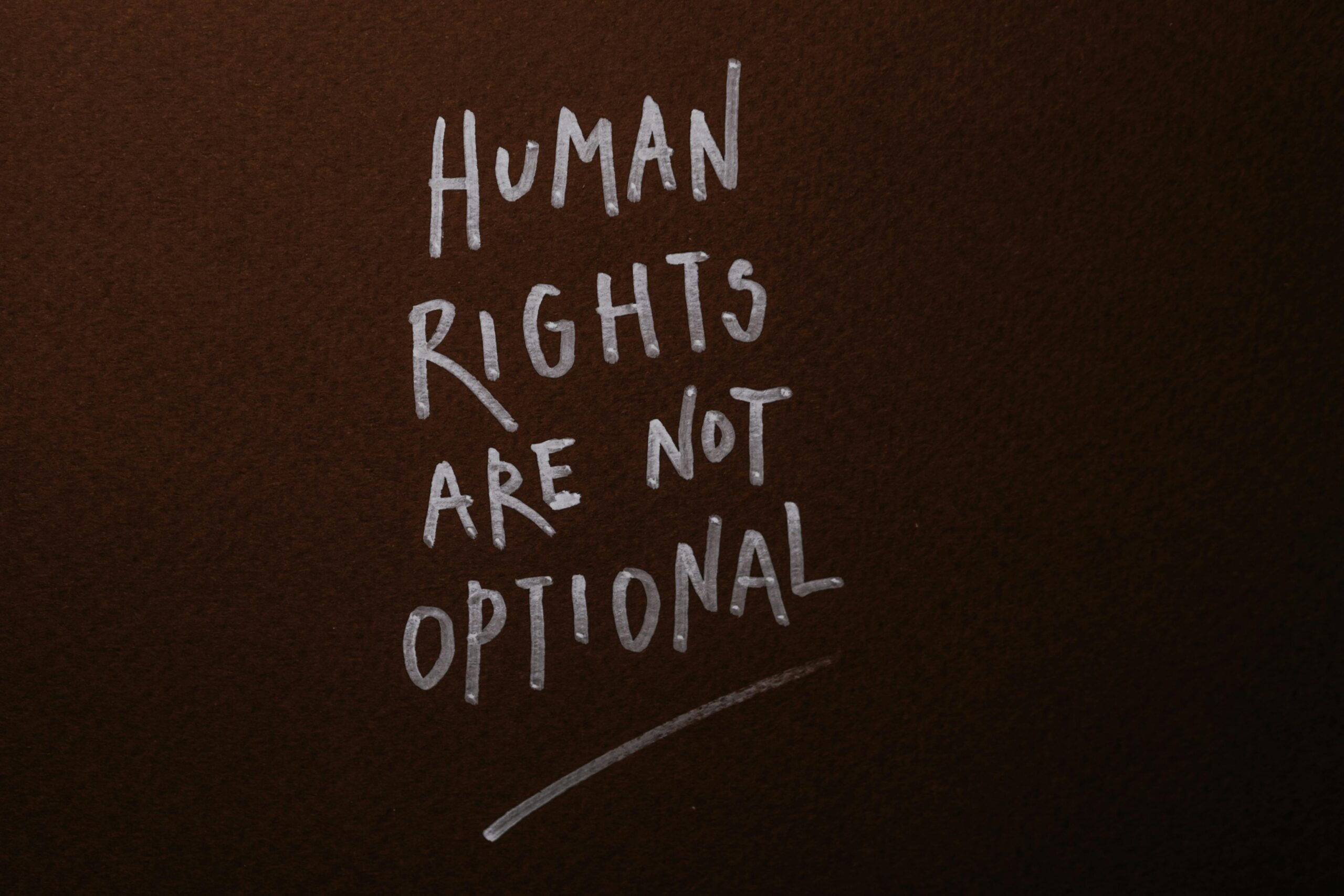 Provide a comparative and critical analysis of the human rights granted by Islam with those enshrined in the Universal Declaration of Human Rights (UDHR). Handwritten message advocating for human rights on a rich brown background.