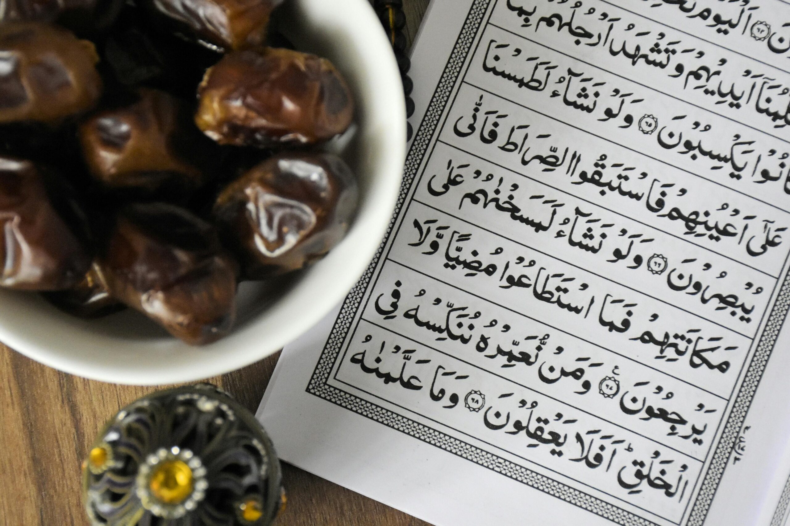 Fast/Soum/Roza and its impacts with explanation of its philosophy A bowl of dates with Quran, symbolizing Ramadan iftar tradition.