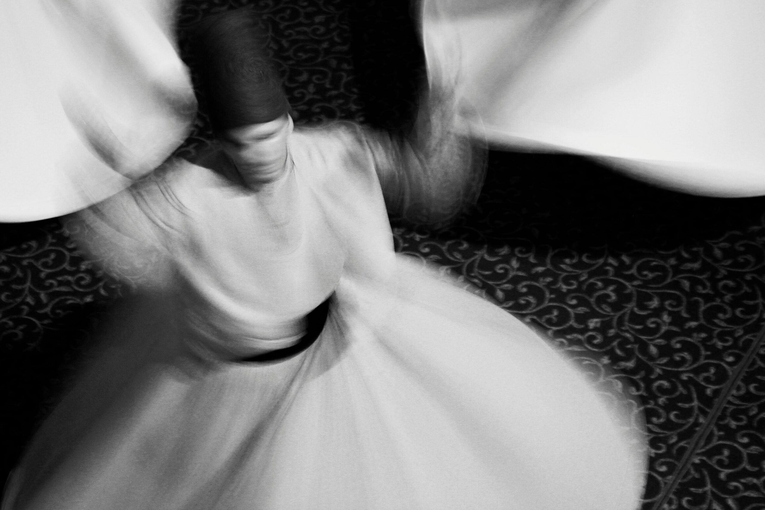 Sufism Explained: The Path of Divine Love and Spiritual Closeness Blurred motion of a Sufi whirling dervish, showcasing spiritual dance and white attire.